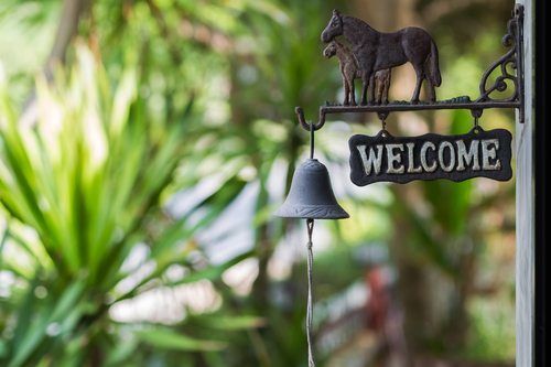Vintage welcome plate with horses and bell in the garden