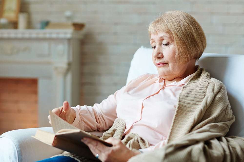 Senior female reading in arm-chair