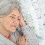 Close-up of senior woman asleep on quilt