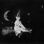 Vintage photo of women in witch costume, moon backdrop