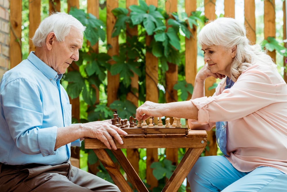 Senior couple playing chess outdoors