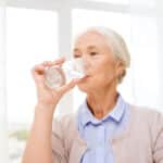 Senior woman drinking glass of water