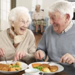 smiling senior couple eating together