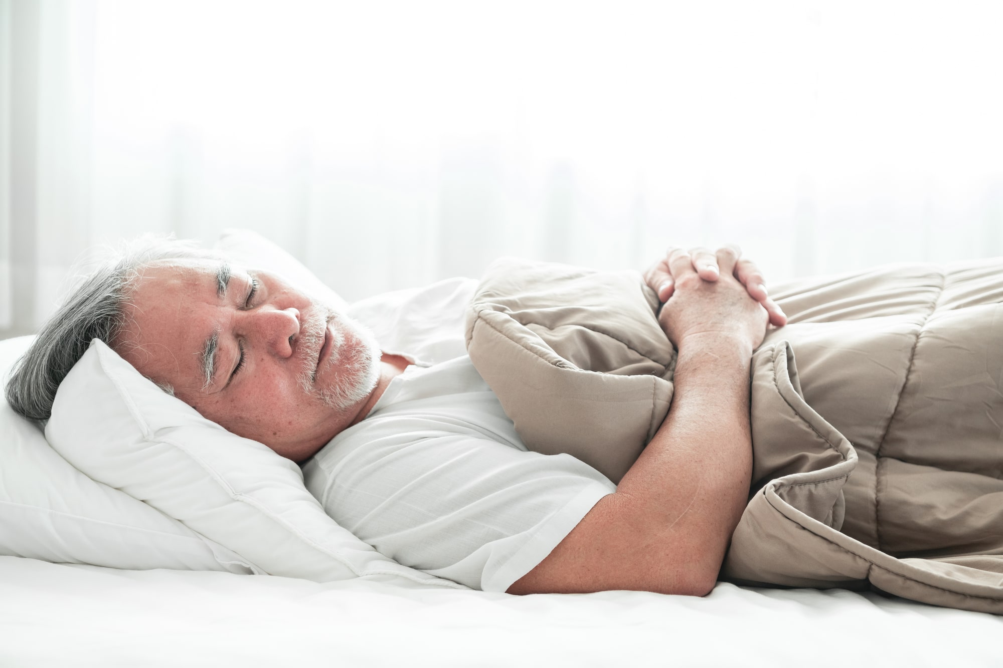 Senior man sleeping peacefully in bed