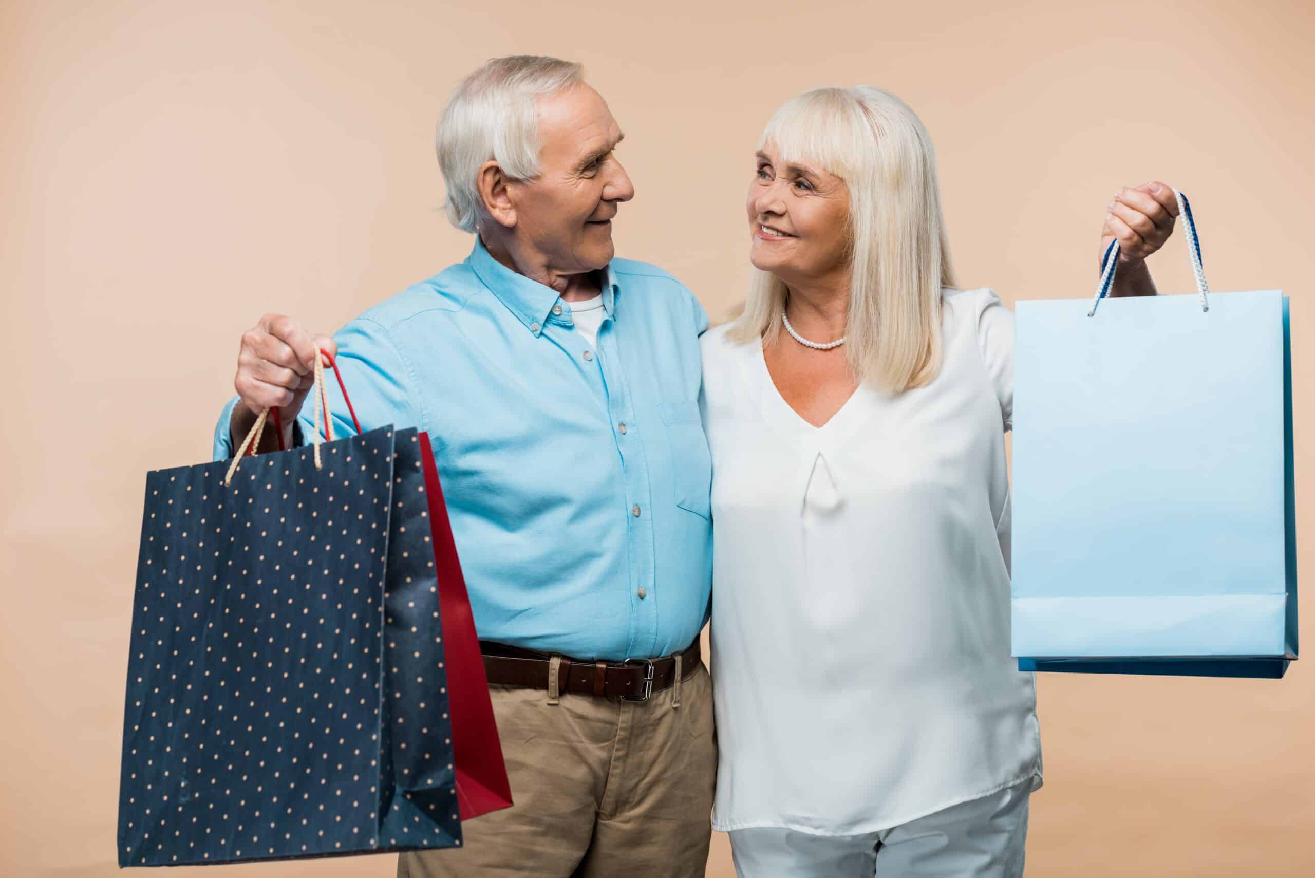 Two seniors holding shopping bags