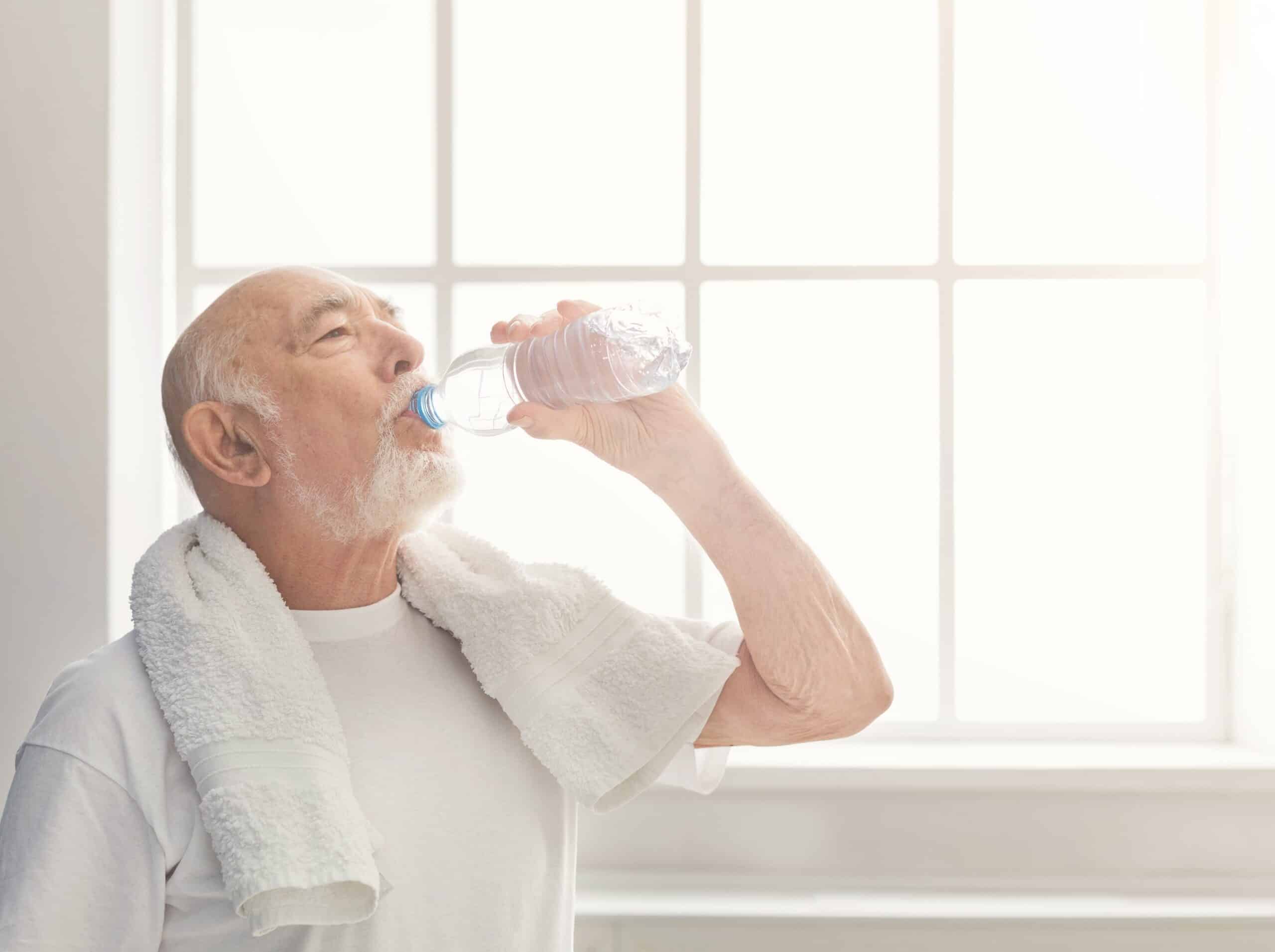 Senior man in the gym drinking water