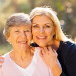 Smiling senior woman and adult woman outside